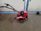 a small red machine that is sitting on the ground