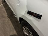 a close up of a white car with a sticker on it