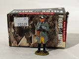 figurine of a man in uniform standing in front of a box