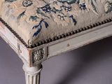 a white bench with a blue and white cushion on top of it