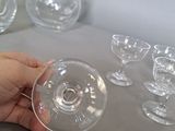 a person holding a wine glass in front of a bunch of empty wine glasses