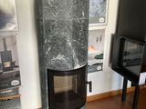 une cheminée au milieu du salon, avec une télévision accrochée au mur