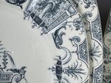 two blue and white plates with designs on them