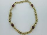 un gros plan d'un bracelet en or orné de pierres violettes