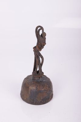 statue of a man holding a bird on a bell