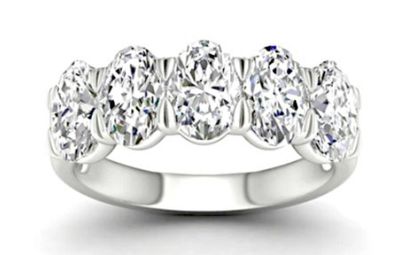 a close up of a five stone diamond ring on a white background