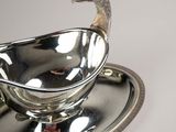 a silver plate with a peacock on top of it