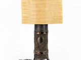 a close up of a lamp on a table with a lamp shade on it