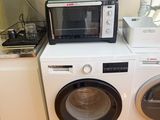 a microwave and a washing machine in a kitchen