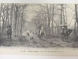 a black and white photo of a group of people riding horses in the woods