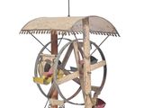 une sculpture en bois représentant un rouet surmonté d'un drapeau
