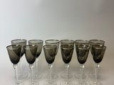 six verres à vin sont alignés sur une surface blanche