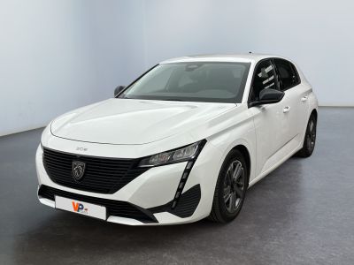 La voiture blanche est garée dans une grande pièce au sol noir