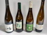 three bottles of wine are lined up on a white surface