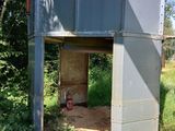 des toilettes au milieu d'un champ à côté de quelques arbres
