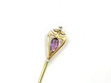 an image of a gold stick with a purple stone in the middle