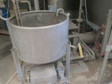 a large metal pot sitting on a cart in the middle of a room