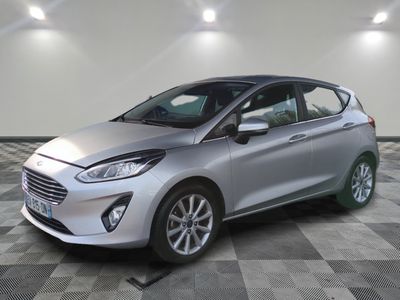 une Ford Fiesta argentée garée sur un sol en carrelage à damier