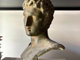 a bust of a man sitting on top of a book