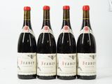 quatre bouteilles de vin rouge sont alignées sur une surface blanche