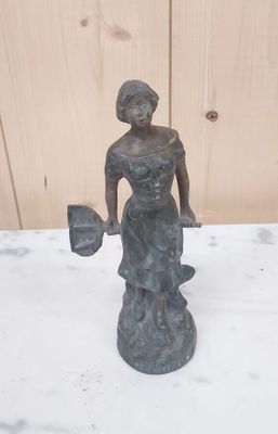 une statue représentant une femme tenant un éventail, posée sur une table