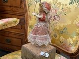 a doll sitting on a chair in the middle of a room