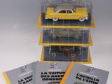 trois petites voitures jaunes empilées les unes sur les autres sur une table
