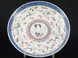 une assiette blanche et bleue décorée d'oiseaux et de fleurs