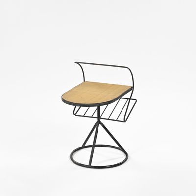 a black metal chair with a wooden seat and a magazine rack