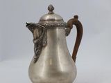 une cafetière ancienne en argent avec une anse, sur fond blanc