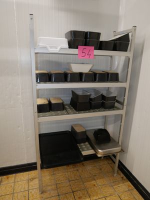 une étagère sur laquelle sont posés des casseroles et des poêles, dans une pièce