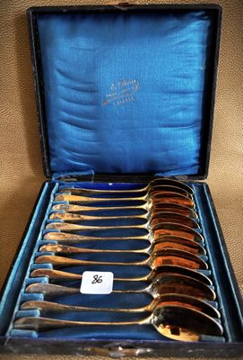 six spoons in a case with a blue cover