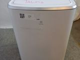 a white washing machine sitting on the floor next to a curtain