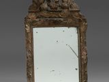 un miroir orné d'un oiseau et d'une horloge au centre