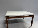 a white coffee table with a wooden frame and a white top