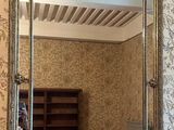 un miroir accroché au mur au-dessus d'un lit dans une chambre