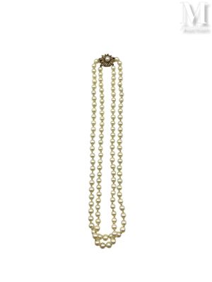 a close up of a necklace with pearls on a white background