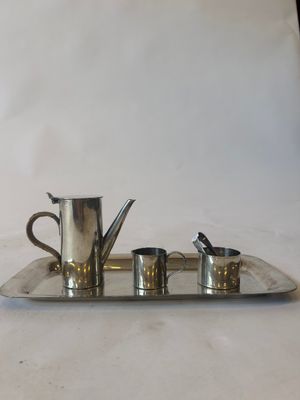 a silver tray with four cups and a teapot on it