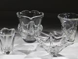 trois vases en verre posés sur une table, sur fond noir