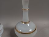 a white vase with a gold rim sitting on a table