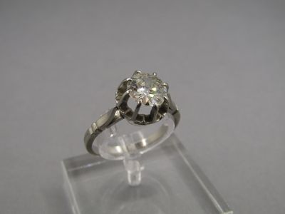 un gros plan d'une bague en diamant posée sur une vitrine transparente