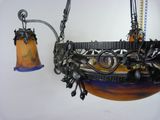 a hanging lamp that has a bell hanging from it ' s side