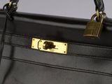 the handle of a black purse with a padlock on it