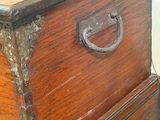 a wooden chest with a metal handle on top of it