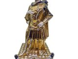 gold and white figurine of a man in armor with a sword