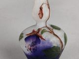 a glass vase with a flower on it on a table