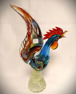 a glass sculpture of a rooster on a glass base