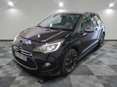 la voiture noire est garée sur un sol en damier dans le garage