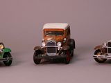 three toy cars sitting side by side on a gray surface