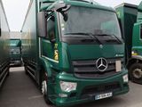 deux camions verts garés l'un à côté de l'autre sur un parking
